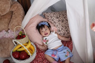 High angle view of cute baby girl lying on bed