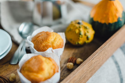 Morning coffee with pumpkin muffins on a wooden tray.