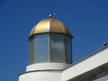 Low angle view of cross on building against clear sky