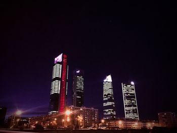 Low angle view of illuminated buildings against sky at night