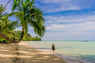 Rear view of woman walking on beach