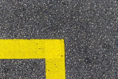 High angle view of yellow arrow symbol on road