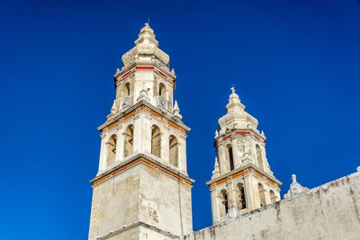 Low angle view of bell tower against blue sky