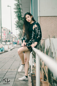 Portrait of young woman sitting outdoors