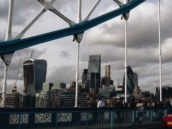 City at waterfront against cloudy sky