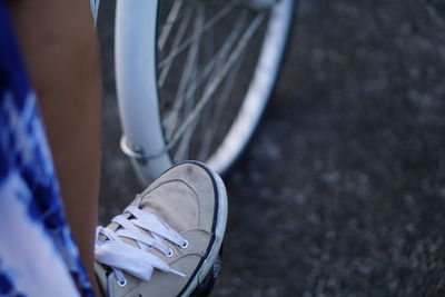 Low section of woman cycling on road