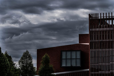 Low angle view of apartment building against cloudy sky