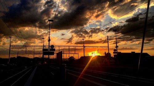 Railroad track against cloudy sky at sunset