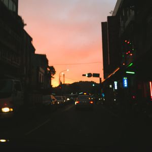 Traffic on city street at sunset