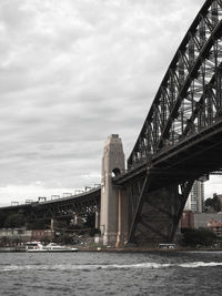 Bridge over river against cloudy sky