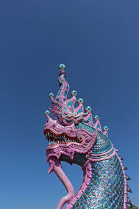Low angle view of statue against blue sky