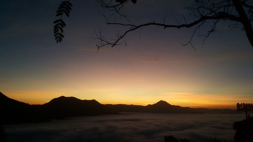 Scenic view of silhouette mountains against orange sky