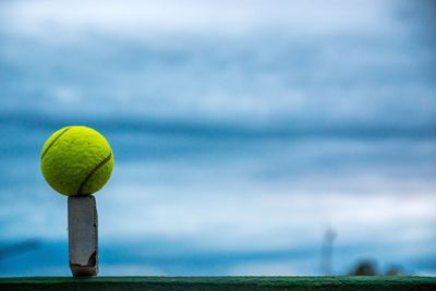 Close-up of tennis ball 
against sky