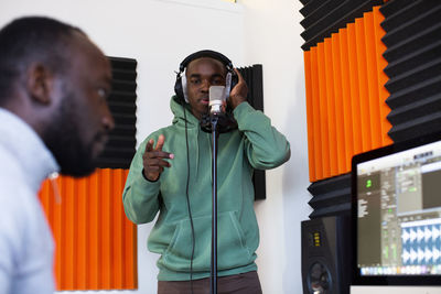 Rapper and sound engineer recording song in studio