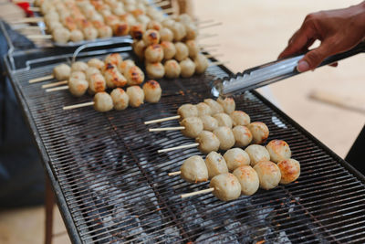 Midsection of person preparing food on barbecue grill