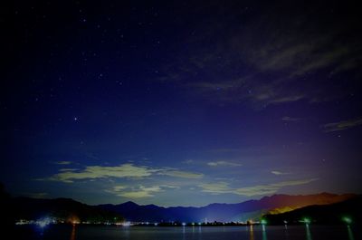 Scenic view of lake against sky at night