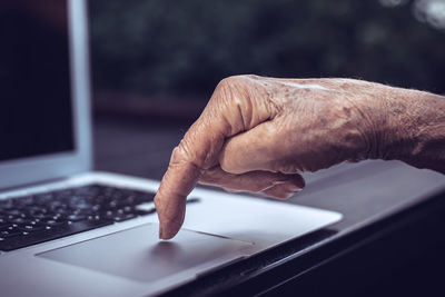 Old persons finger on computer keyboard