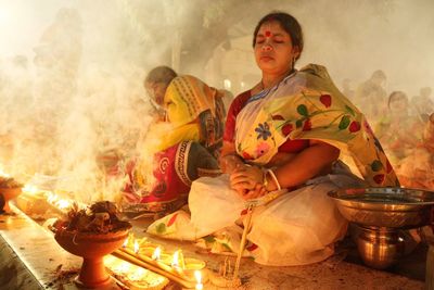 Doing prayer at barodi lokhnath brahmachari ashram infront of burning candle and diya- oil lamp