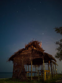 Gazebo by house against sky at night