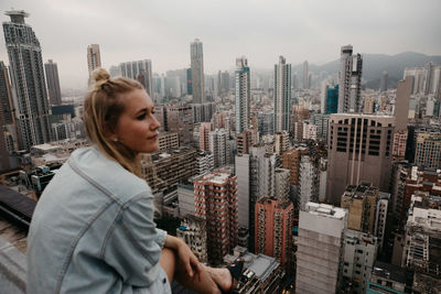 Mid adult man in city against sky