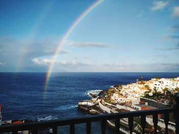 Scenic view of rainbow over sea against sky