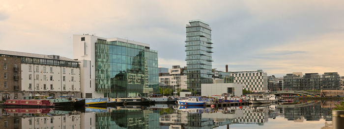 Reflection of buildings in city against sky