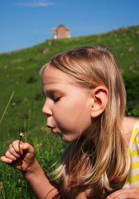 Portrait of girl holding plant in field