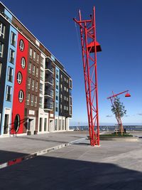 Red construction site by building against clear sky