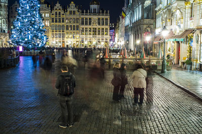 Woman in illuminated city at night