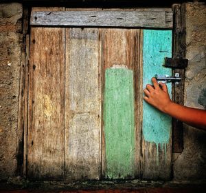 Man holding closed door of old building
