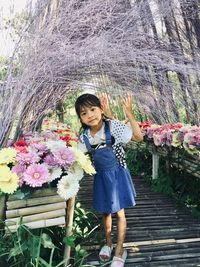 Full length portrait of girl standing against wall