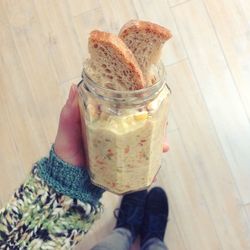 Low section of woman holding food in jar