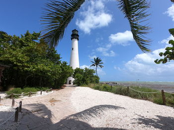 Palm trees and lighthouse against sky