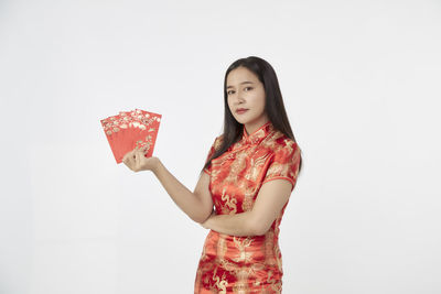 Portrait of a smiling young woman against white background