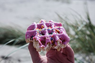 Cropped hand having waffle outdoors