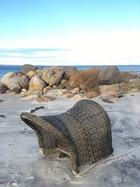 Rock on beach against sky