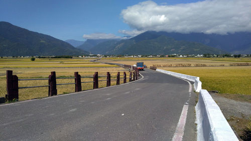 Rear view of people riding motorcycle on road