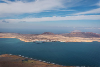 Aerial view of sea and mountains against sky