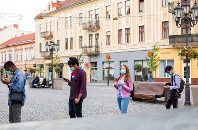 People walking on street against buildings in city