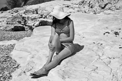 Woman sitting on sand at beach