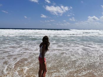 Full length of woman on beach against sky