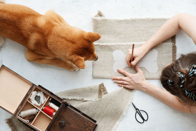Top view of woman making eco friendly textile bone for her domestic dog. diy toys and treats