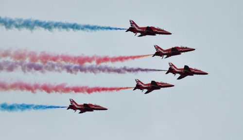 Low angle view of airshow against sky