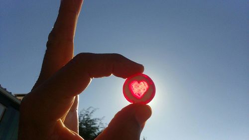 Close-up of hand holding hands against clear sky