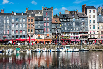 Boats moored in canal against buildings in city