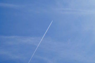 Low angle view of vapor trail against blue sky