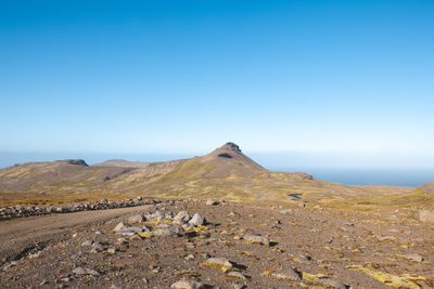 Scenic view of desert against clear blue sky