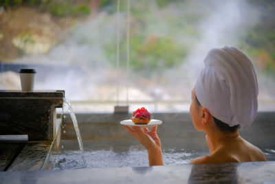 Rear view of woman holding ice cream