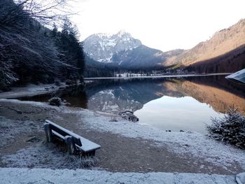 Scenic view of lake by snowcapped mountains against sky