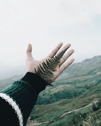 Midsection of person on mountain against sky